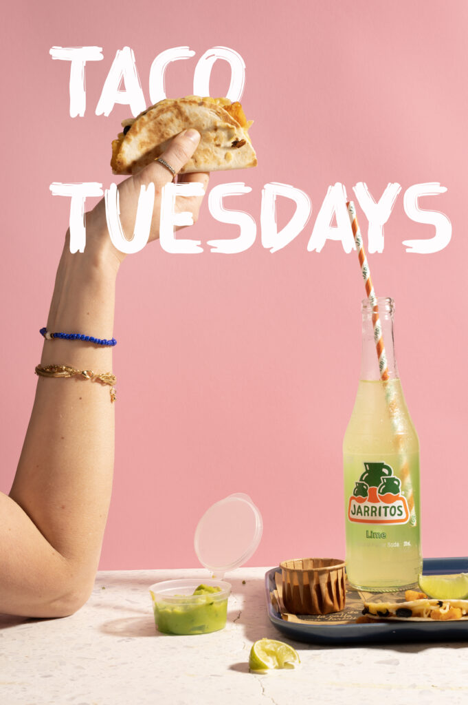 Vrouwenhand met taco. Tekst: Taco Tuesdays